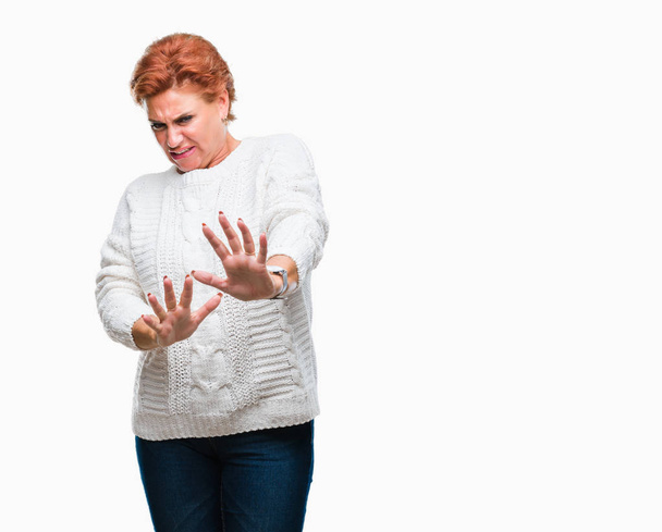 孤立した背景に冬のセーターを着て館シニア白人赤毛女性うんざり表現で、不快と恐ろしいので嫌悪顔をやって嫌悪反応。手で発生します。迷惑な概念. - 写真・画像