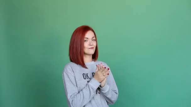 Csinos lány mutatja egy üzenetet neki jersey felső zöld háttér. - Felvétel, videó
