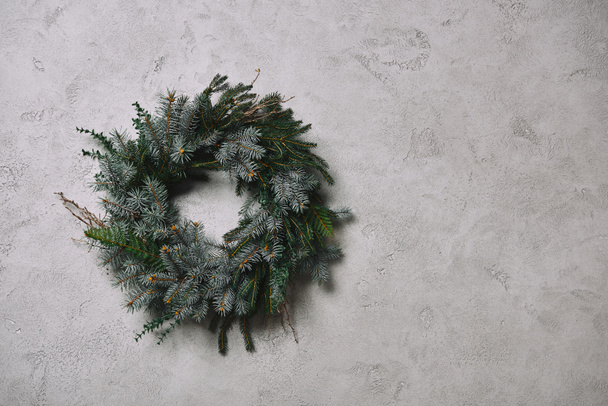 круглі fir вінок для різдвяні прикраси висить на сірий стіни в кімнаті - Фото, зображення