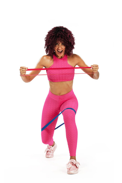 Muscular young fit sports woman athlete in pink sportswear with bands or expander in gym. Copy space for fitness nutrition ads. - Foto, Imagen