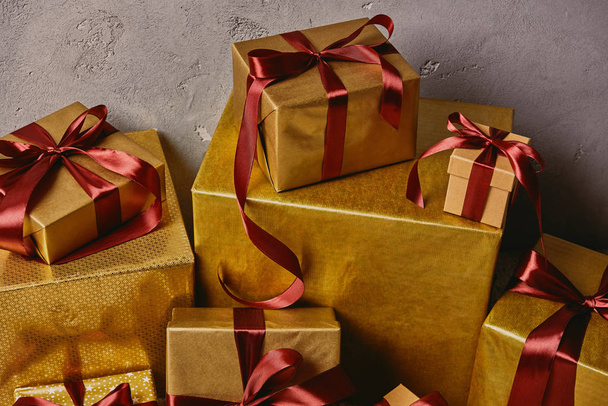закрыть золотые рождественские подарочные коробки на куче в комнате
 - Фото, изображение