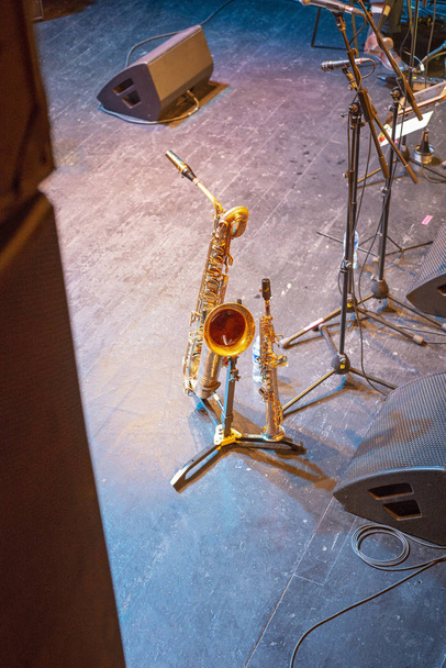Кларнет и саксофон стоят на сцене. Перерыв на фестивале качелей
. - Фото, изображение