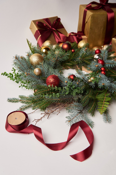 Cajas de regalo de Navidad, corona de abeto y carrete de cinta para la decoración aislada en blanco
 - Foto, imagen