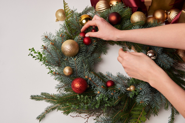 cropped image of woman decorating christmas fir wreath isolated on white - Photo, Image
