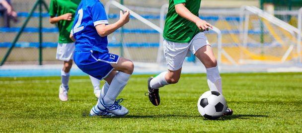 Jonge jongens schoppen voetbalwedstrijd. Soccer Academy spelers spelen toernooienspel op een worp - Foto, afbeelding
