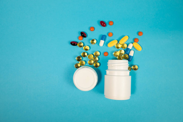 Various pills in bottle on blue background - Photo, Image