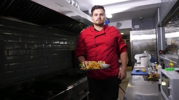 Cook brengen uit de keuken van een plaat met sandwiches en Franse frietjes - Video