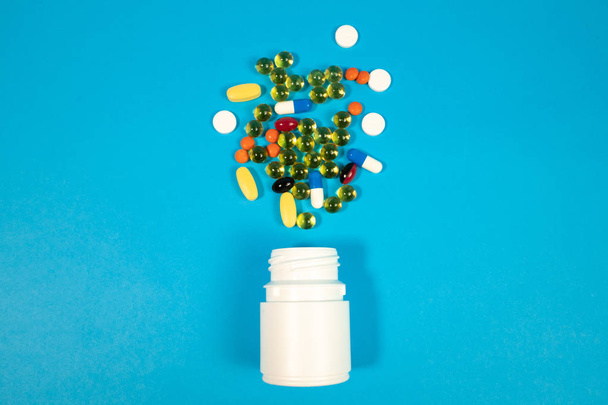Various pills in bottle on blue background - Foto, immagini