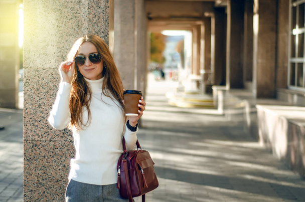 Young woman sweater sunglasses cup of coffee female red bag - Fotoğraf, Görsel