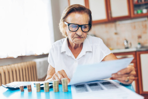 Senior woman at home checking her finances and investments - Foto, immagini