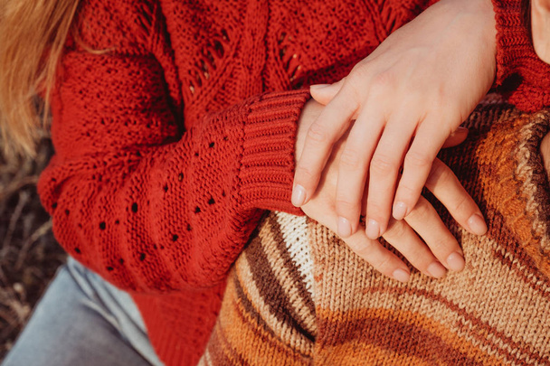 Γυναίκα στο κόκκινο πουλόβερ, κρατώντας τα χέρια της στον ώμο του τον άντρα της. - Φωτογραφία, εικόνα