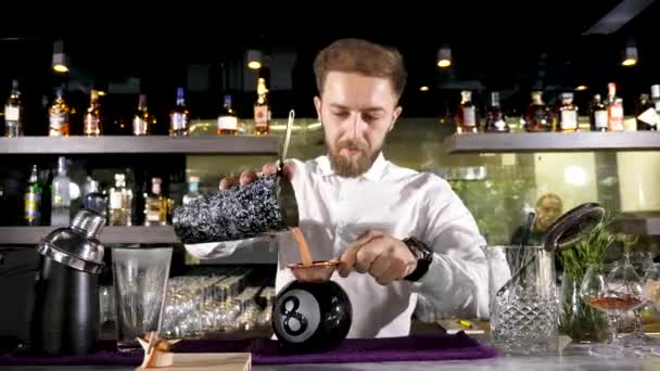 Бармен розливу змішаних коктейль в 8ball скла - Кадри, відео