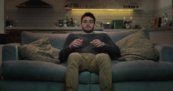 Mann entspannt sich auf Sofa im Wohnzimmer - Filmmaterial, Video