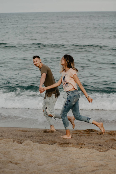 Happy couple in love walking on the beach - Фото, изображение