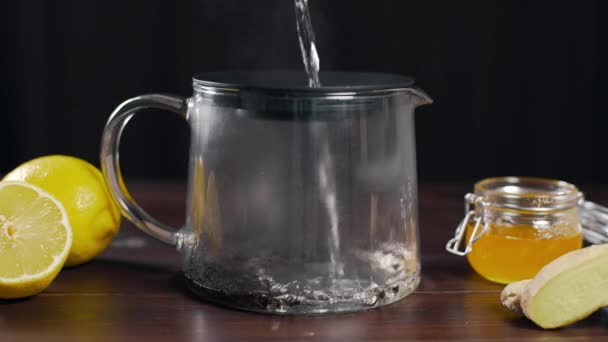 Água fervente é derramada no bule com chá preto, chá de vitamina com limão, gengibre e mel, bebida contra a doença, bebidas quentes
 - Filmagem, Vídeo