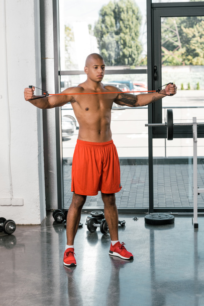 izmos afro-amerikai sportoló, stretching zenekar edzőteremben gyakorlása - Fotó, kép