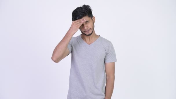Young stressed bearded Indian man having headache - Filmmaterial, Video
