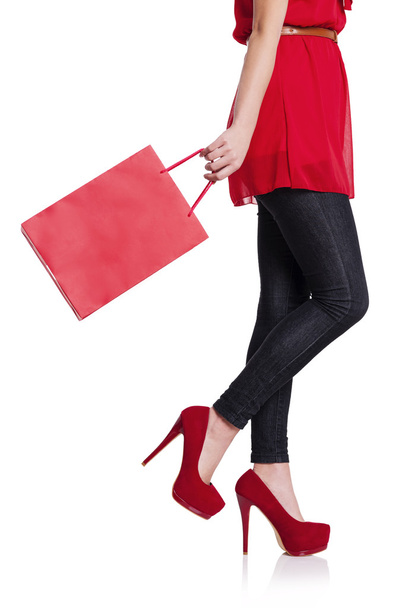 Seção baixa de uma mulher com seu saco de compras vermelho
 - Foto, Imagem