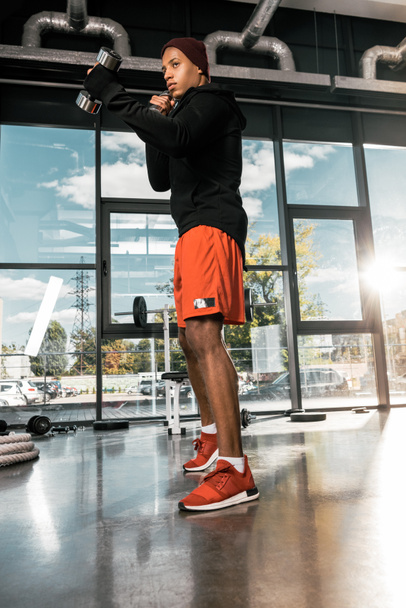 vue à faible angle de boxeur homme afro-américain pratiquant avec des haltères à la salle de gym
 - Photo, image