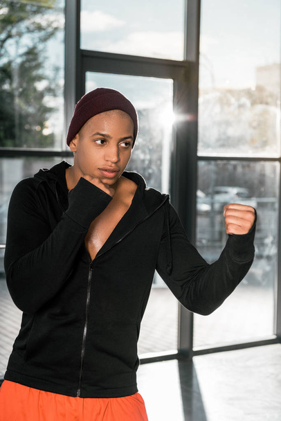 knappe jonge Afro-Amerikaanse bokser uit te oefenen op sportschool - Foto, afbeelding