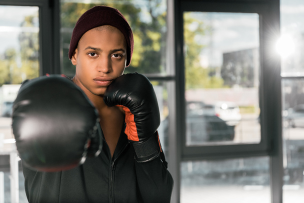 молодий афроамериканський боксер в боксерських рукавичках вправляється в спортзалі
 - Фото, зображення