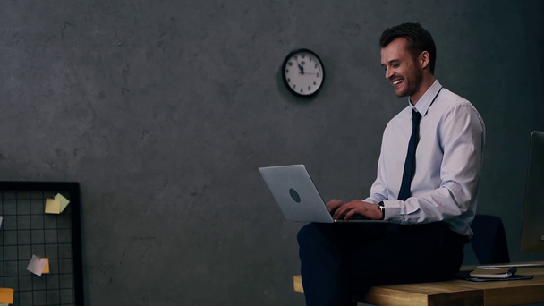 улыбающийся бизнесмен в формальной одежде с помощью ноутбука в офисе
 - Кадры, видео