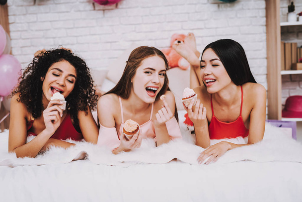 Girl Lying on Bed. Celebrating Women's Day. Emotional Women. Bed with White Plaid. White Interior. International Women. Happy Womens Day. Smiling Women on Bed. Happy Face. Smiling Girls with Cupceke. - 写真・画像