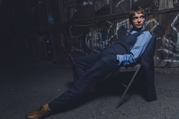 Queer woman dressed in suit and tie poses in a grungy industrial location - Photo, Image