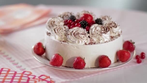 Cake with whipped cream and strawberries on a stand, close-up. Scene. Sliced No Bake Strawberry Cheesecake Decorated with Fresh Berries. Homemade cake made from cream with strawberries and raspberries - Footage, Video