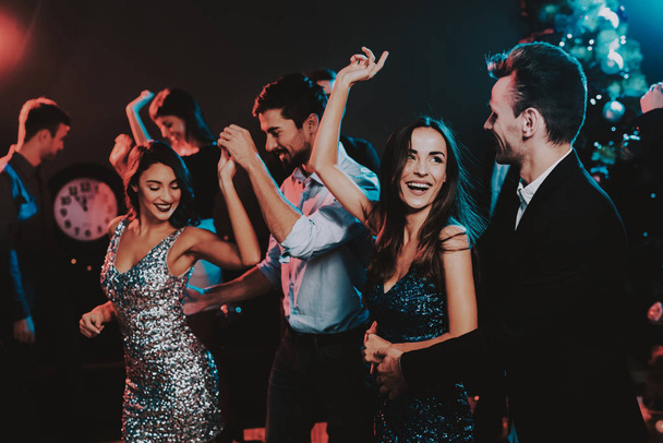 Happy Young People Dancing on New Year Party. Happy New Year. People Have Fun. Indoor Party. Celebrating of New Year. Young Woman in Dress. Young Man in Suit. Happy People. Modern Dances. - Photo, Image