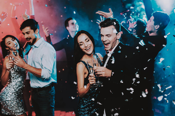 Happy Young People Dancing on New Year Party. Happy New Year Concept. Glass of Champagne. Celebrating of New Year. Young Woman in Dress. Young Man in Suit. Happy People. Modern Dances. - Photo, Image
