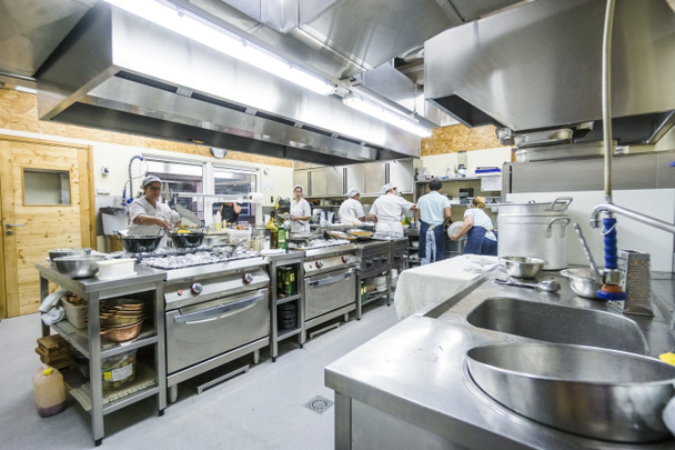 Персонал кухні зайнятий приготуванням їжі під час обіду в ресторані
 - Фото, зображення