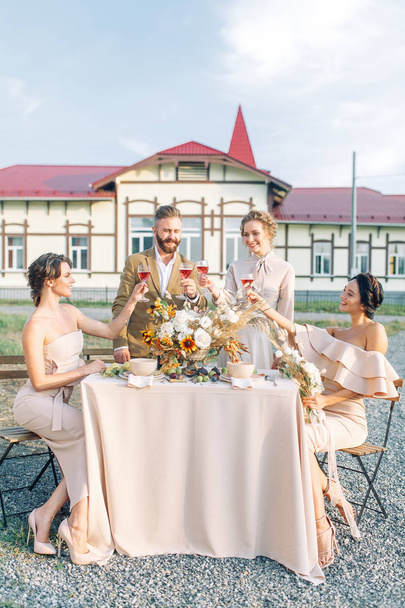 Wedding with close friends, at sunset at his home. American style and happy faces. The friends of the bride, festive table and the happy bridegroom. Wedding reception ideas - Foto, imagen