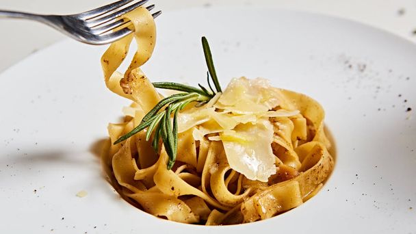 Close-up italian pasta plate with grated parmesan cheese and basil leaf - Foto, Imagem