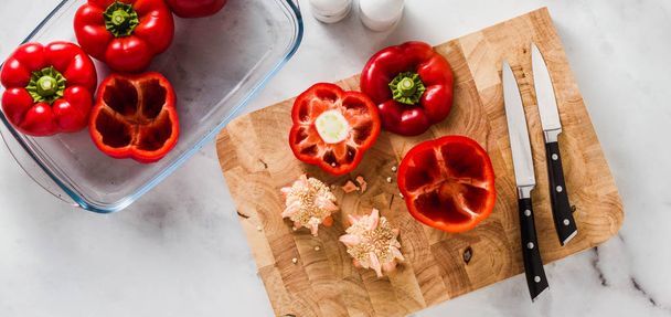 banner of cleaning bell peppers. preparation for filling. on a cutting board and a knife. on a white marble table. in glass baking dish - 写真・画像