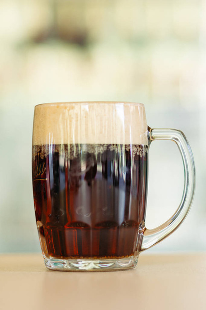Foto de copo de cerveja de vidro em pé na superfície de madeira lisa
. - Foto, Imagem