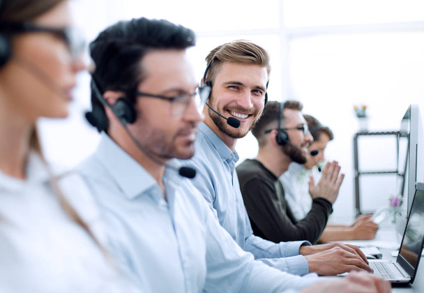 schöner männlicher Kundenbetreuer mit Headset, der im Call Center arbeitet - Foto, Bild