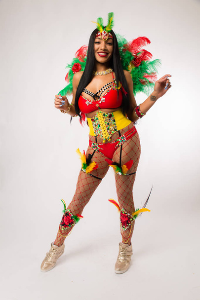 Ajuste joven mujer de raza mixta de pelo oscuro en traje de Carnaval y zapatos deportivos posando sobre fondo blanco limpio
 - Foto, imagen