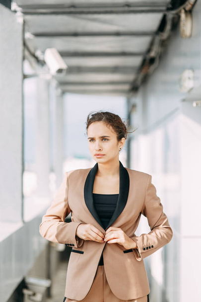 Stylish young business girl. In the city and on the roof. Views and business style. In a hurry and sitting waiting for a meeting. - Фото, зображення
