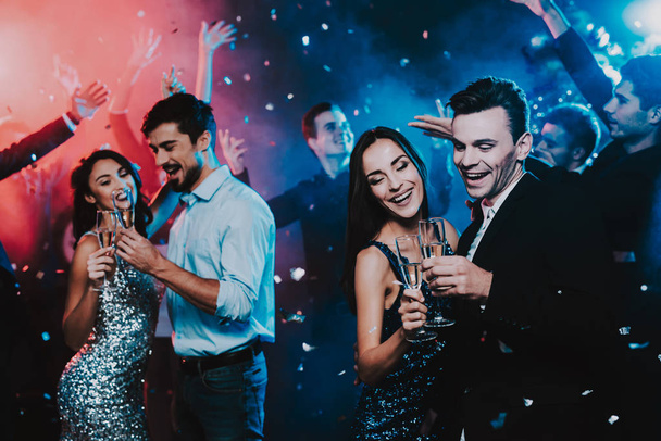 Happy Young People Dancing on New Year Party. Happy New Year Concept. Glass of Champagne. Celebrating of New Year. Young Woman in Dress. Young Man in Suit. Happy People. Modern Dances. - Foto, Imagem