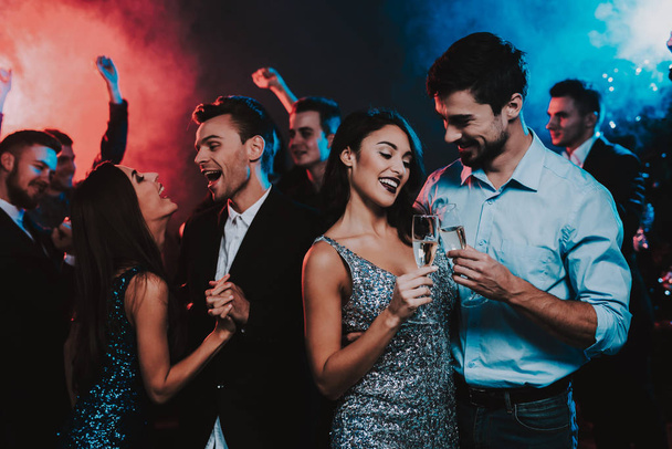 Happy Young People Dancing on New Year Party. Happy New Year Concept. Glass of Champagne. Celebrating of New Year. Young Woman in Dress. Young Man in Suit. Happy People. Modern Dances. - Foto, imagen