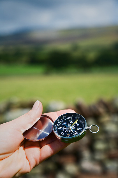 Hand in Hand mit Kompass in ländlicher Umgebung - Foto, Bild