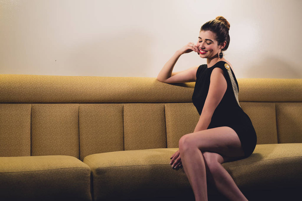 Young caucasian woman dressed like Audrey Hepburn poses in an empty bar - Photo, Image