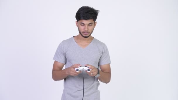 Young tired bearded Indian man playing games and falling asleep - Footage, Video