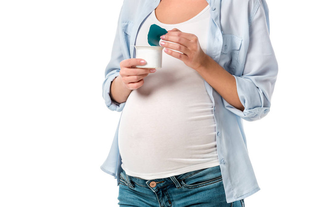 cropped shot of pregnant woman holding yogurt isolated on white - Foto, Imagem