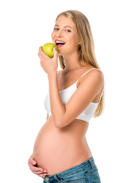 attractive pregnant woman eating green healthy apple isolated on white - Photo, Image
