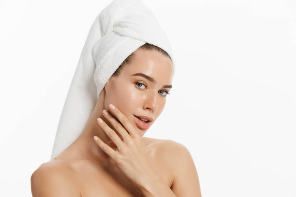 happy young girl with clean skin and with a white towel on her head washes face - Photo, Image
