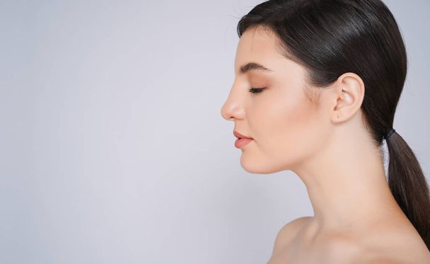 Side view portrait of beautiful with perfect natural skin Portrait. isolated on a light - grey background,with copyspace for slogan or text message. - 写真・画像