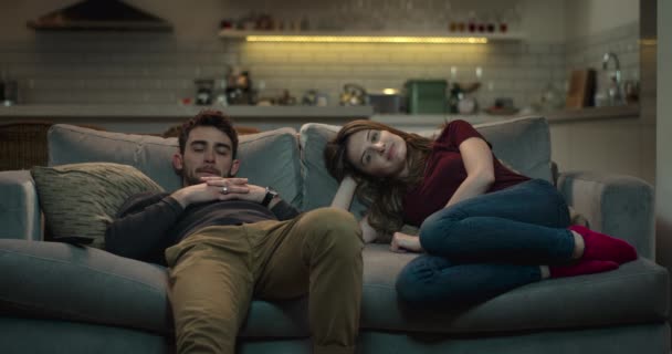 junges, gut aussehendes Paar entspannt auf einem Sofa vor dem Fernseher. - Filmmaterial, Video