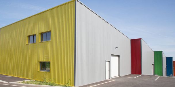 façade grise moderne de bâtiment d'usine faite en panneaux d'aluminium avec des portes et des fenêtres sur le site industriel
 - Photo, image